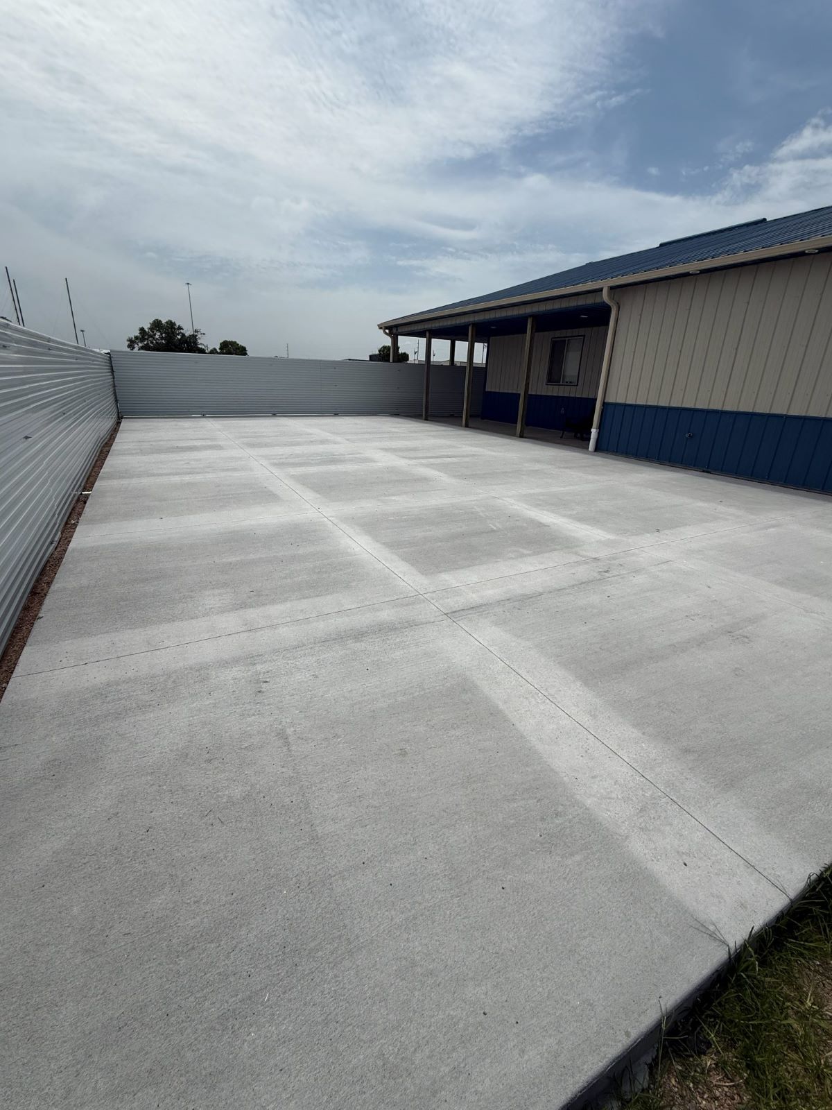Completed outdoor concrete patio at Valley Venue surrounded by a six-foot privacy fence